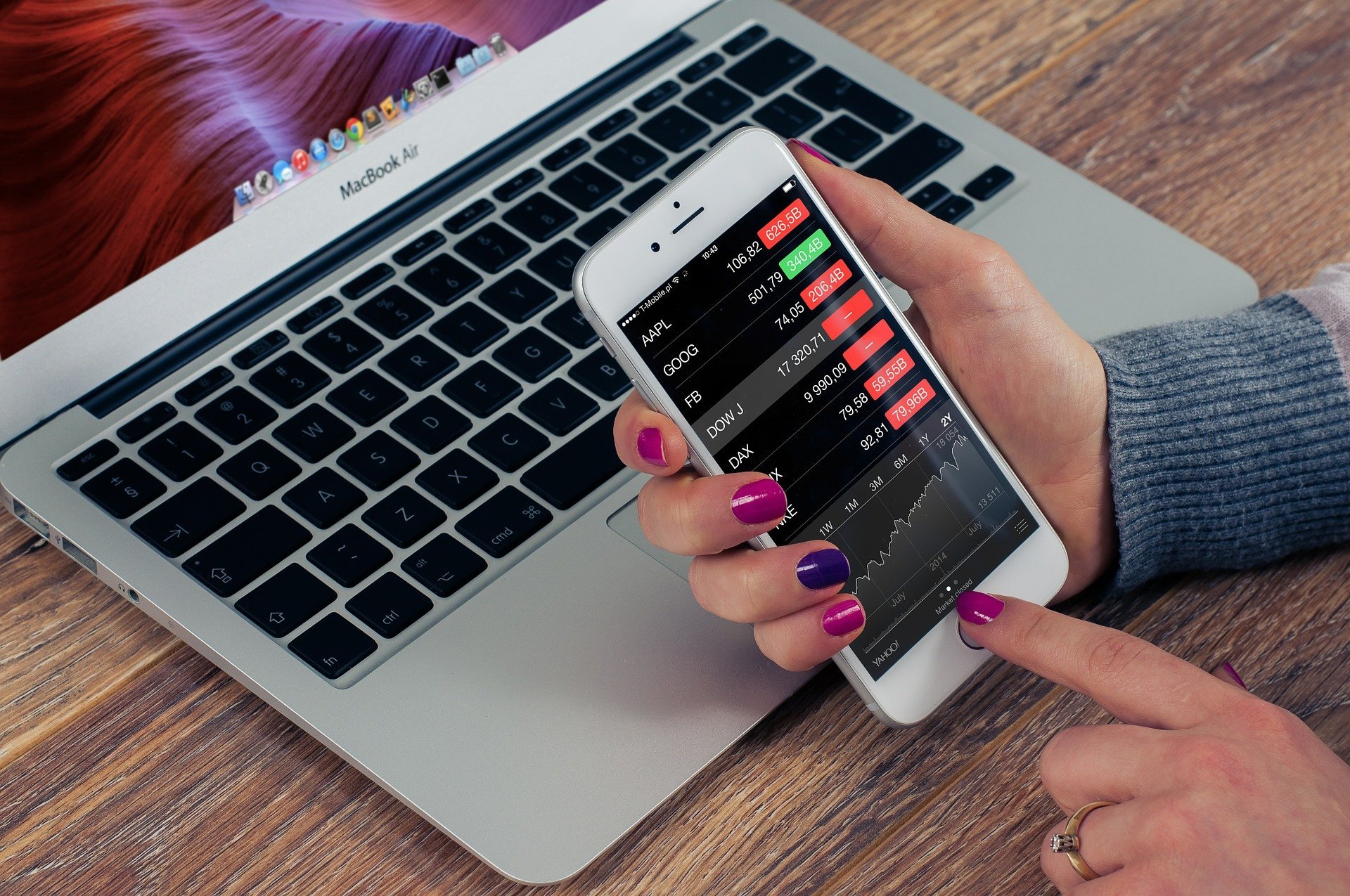 A person holds an iPhone showing a stock portfolio.