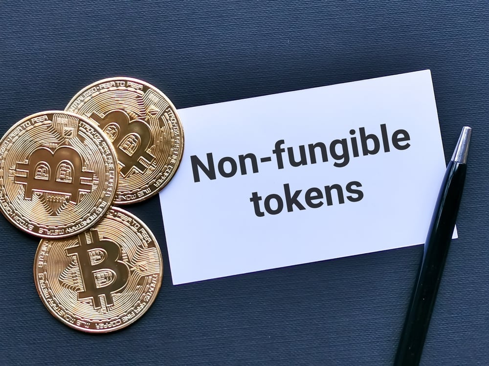 an image depicting bitcoin and a pen next to the words "non-fungible tokens"