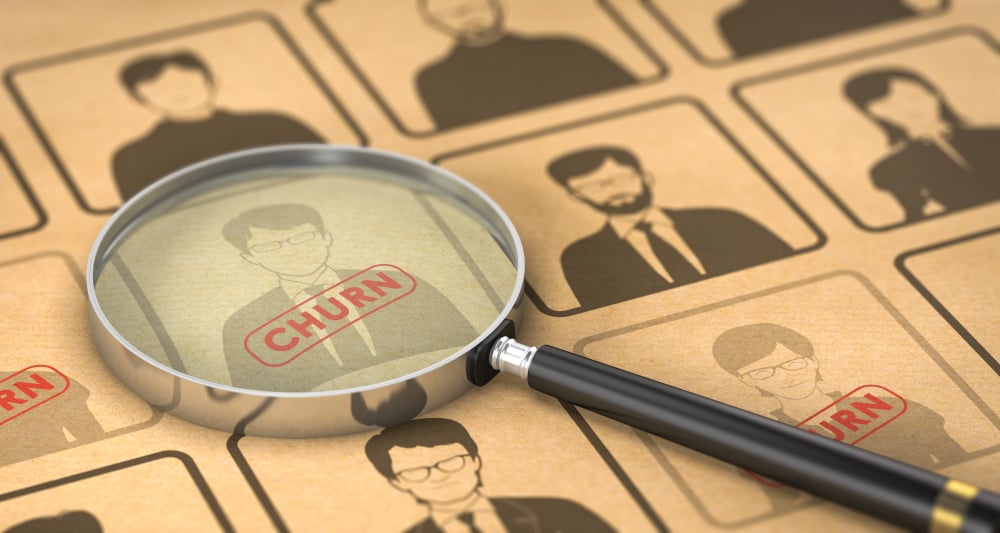 Customer profile images with the word "Churn" under a magnifying glass