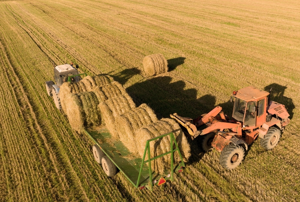 an image of a tractor loading hay in a field
