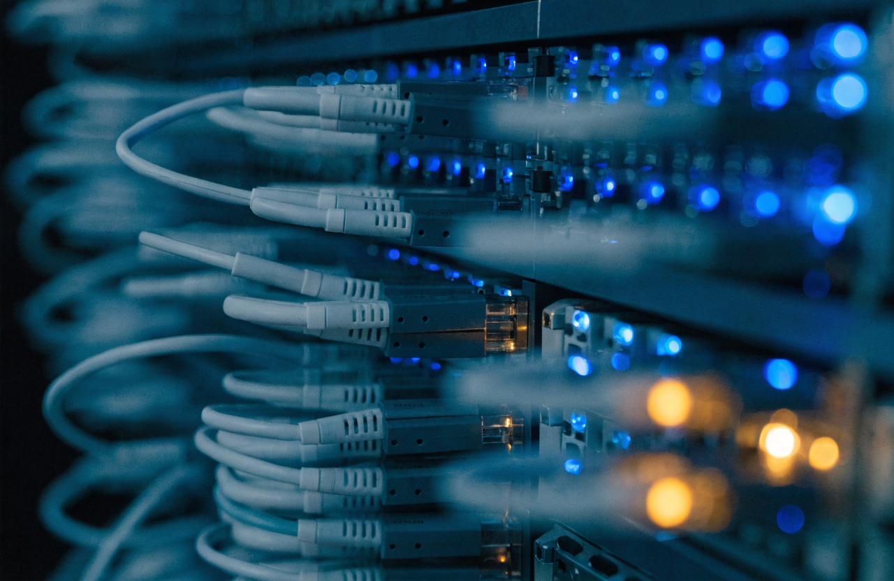 Fiber optic patch cables terminating in a row of transceiver ports on networking equipment, shallow depth of field